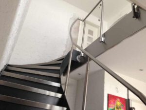 Schwarz pulverbeschichtete Treppe mit Edelstahlgeländer und Stufen in einem Treppenhaus