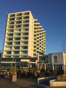 Erneuerung Balkongeländer am Hochhaus Prinz Hamlet an der Ostsee mit Glasscheiben und Edelstahlhandläufen