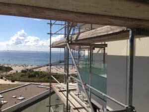 Erneuerung Balkongeländer am Hochhaus Prinz Hamlet an der Ostsee mit Glasscheiben und Edelstahlhandläufen
