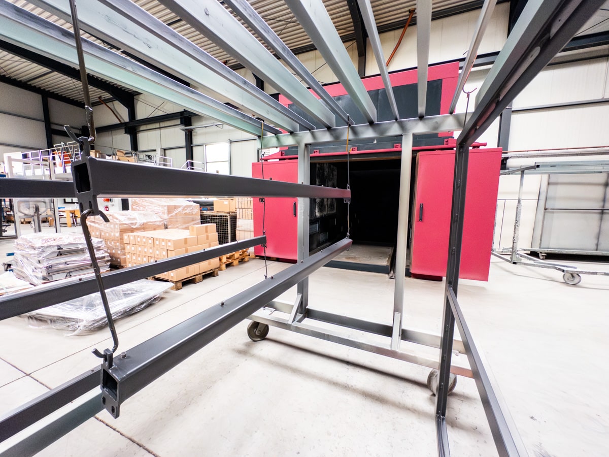 Our in-house powder coating chamber, a central component of our powder coating process, was recently expanded. This modification now enables us to fully and efficiently coat even larger metal parts than before.