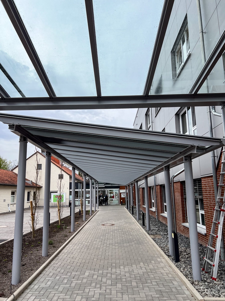Neuer Eingangsbereich für Klinik in Hessisch Oldendorf: Moderne Eingangsüberdachung und neue Edelstahlgeländer konstruiert und vor Ort montiert von HEIKO Metallbau.